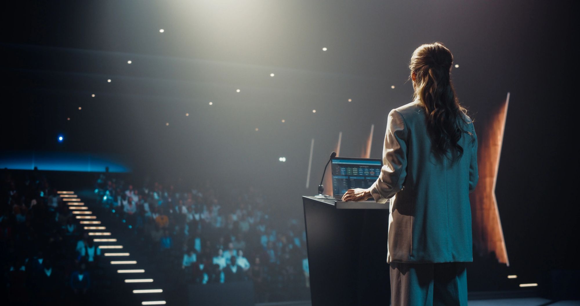 A researcher presenting data from a lectern to a full auditorium.